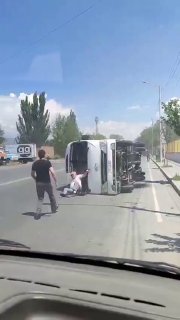 Перевернутый на бок автобус в Аштараке, возле него спасатели